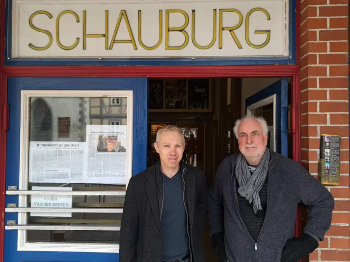 Marius Becker und Wolfgang Würker (r.) stehen nebeneinander vor dem Eingang der neuen Schauburg. 