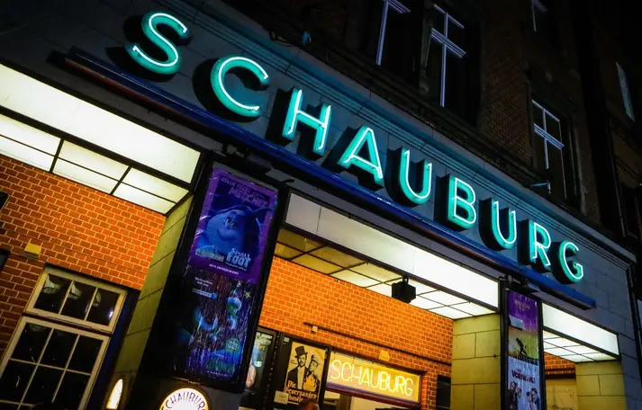 Der Eingang der Schauburg. Oben ist eine Leuchtschrift mit dem Schriftzug "SCHAUBURG" zusehen. 