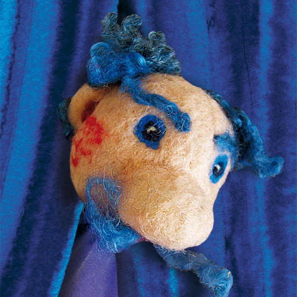 Eine gefilzte Figur schaut durch einen Blauen Vorhang