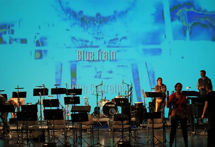 Band auf der DT Bühne, Videoleinwand im Hintergrund, Blue Train