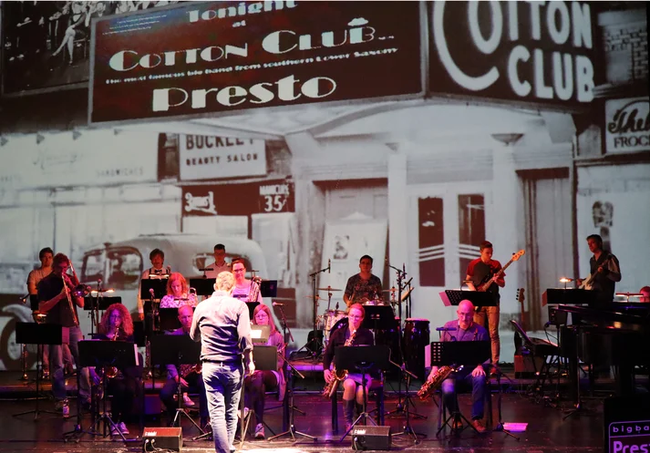 Die Band auf der Bühne des deutschen Theaters Göttingen, Fotoleinwand im Hintergrund, Motiv Cotton Club