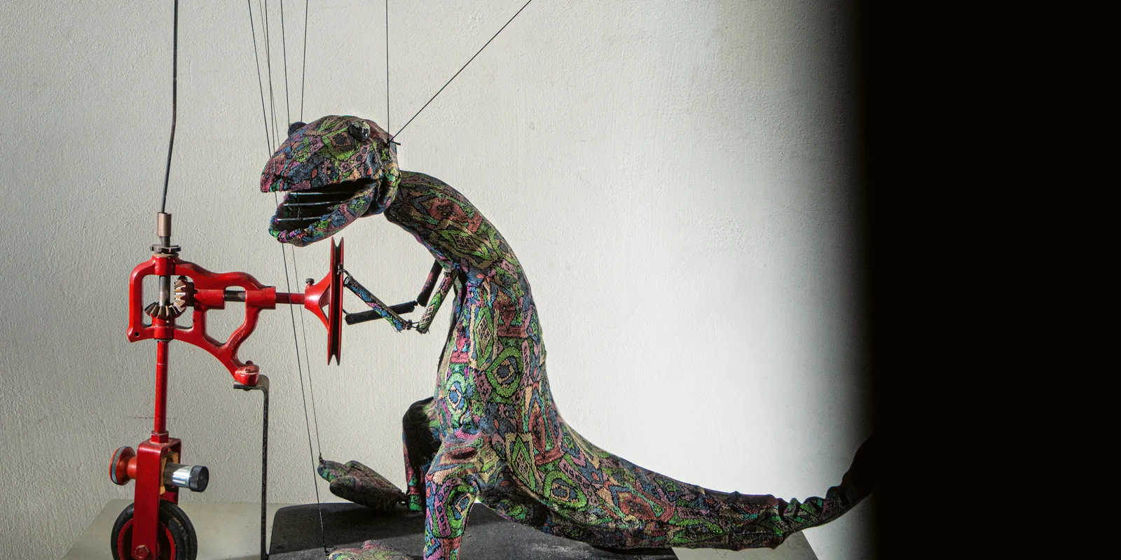 Eine Dinosauriermarionette auf einem Tretroller
