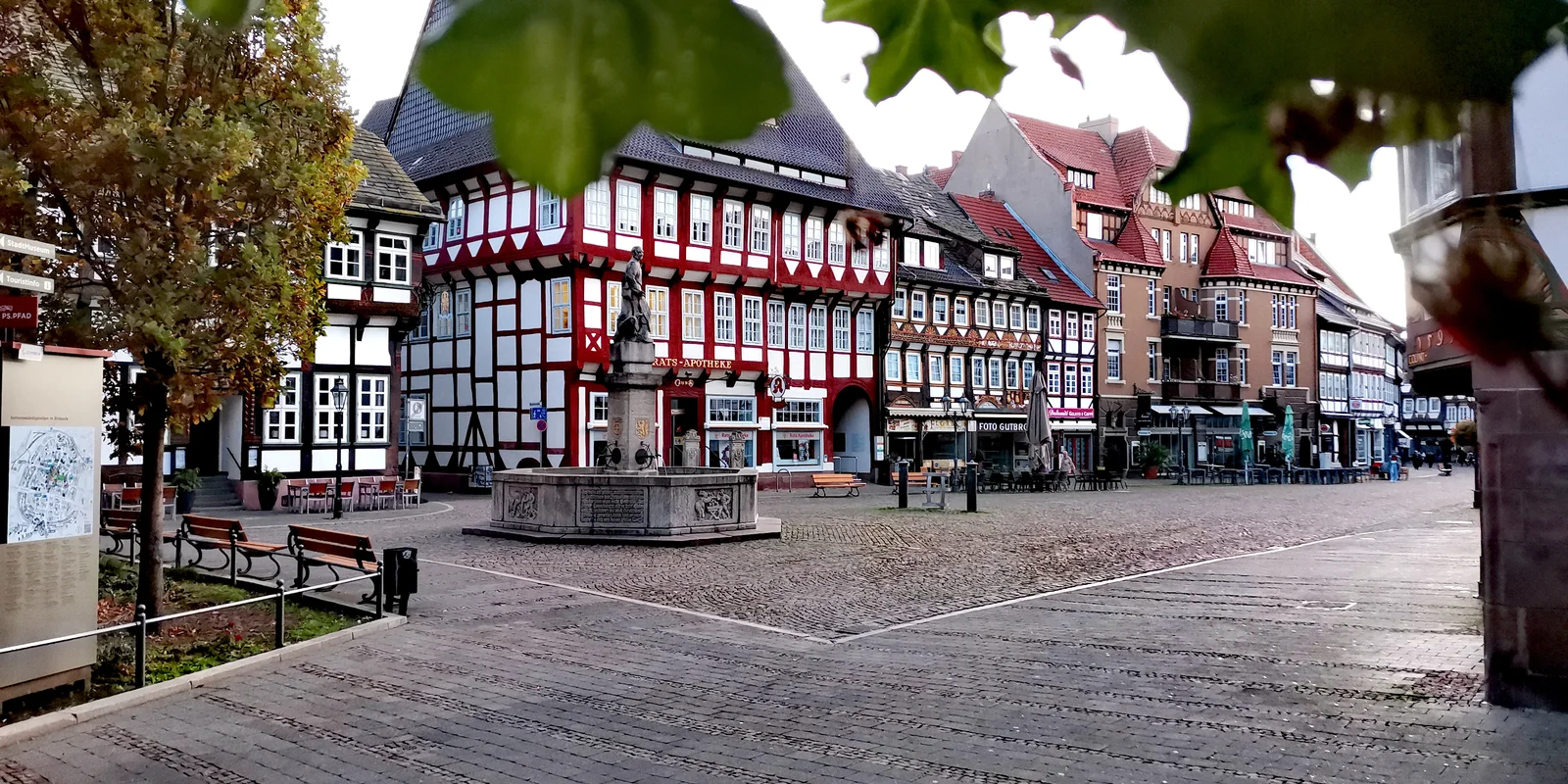 Blick auf den Marktplatz von EInbeck im Hintergrund die Ratsapotheke, davor ein Brunnen