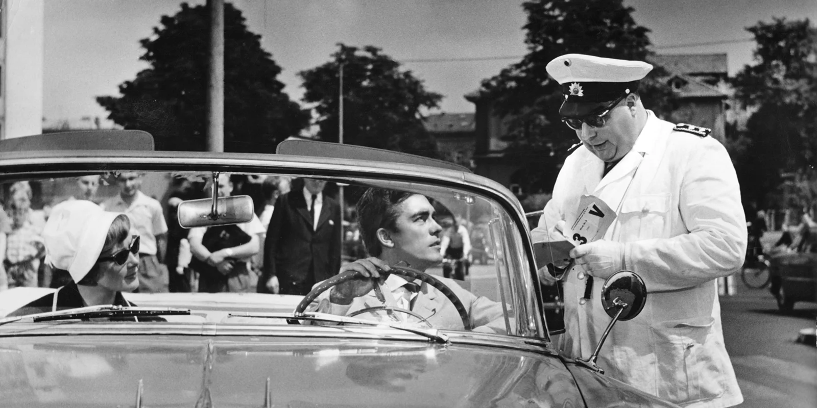 Foto aus dem Film Natürlich die Autofahrer. Heinz Ehrhard als Polizist kontrolliert ein Cabriole mit Erik Schumann mit weiblicher Begleitung am Weender Tor (Blickrichtung Nikolausberger Weg). 