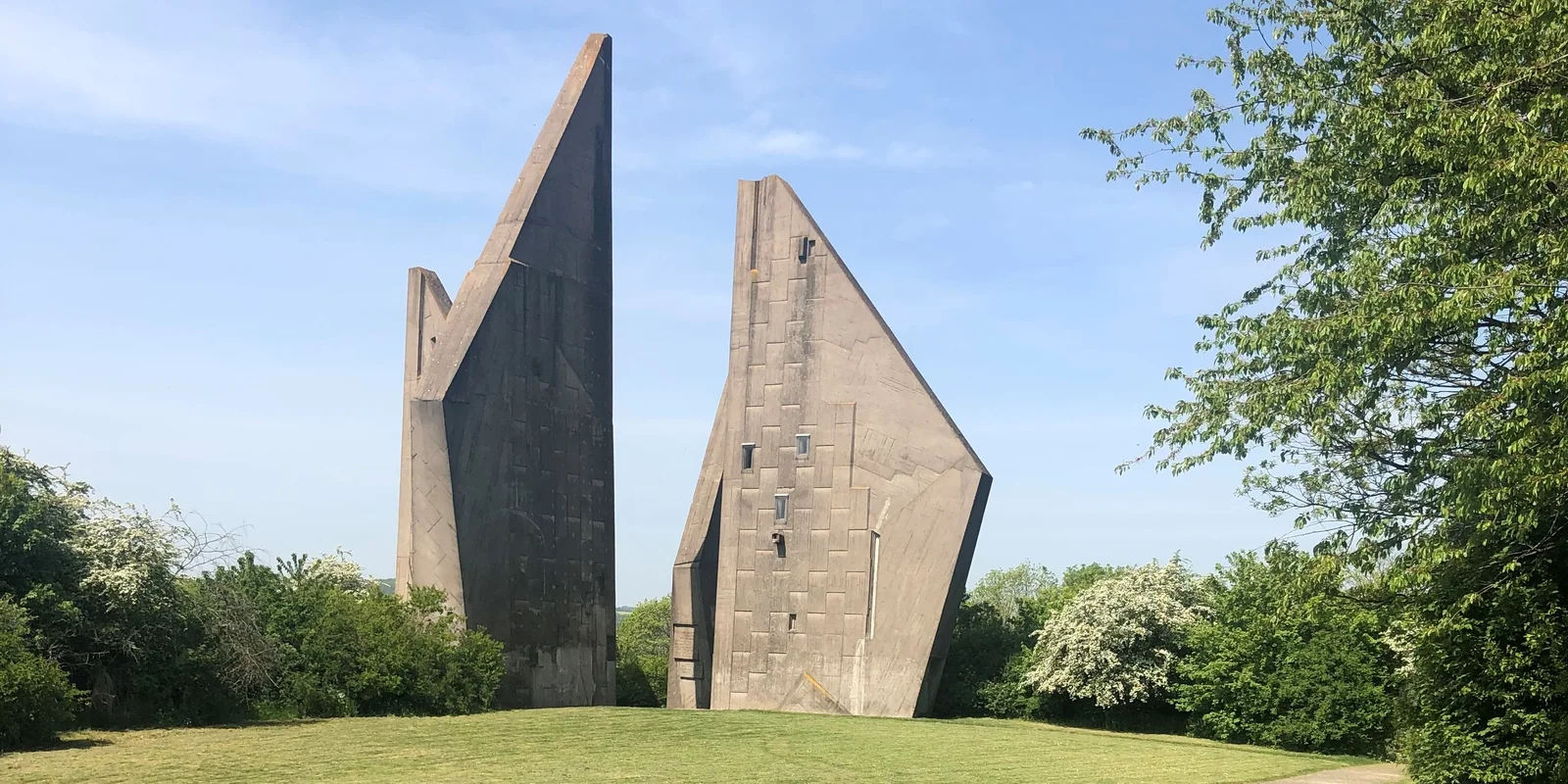 Betonstelen des Mahnmals auf einer grünen Wiese