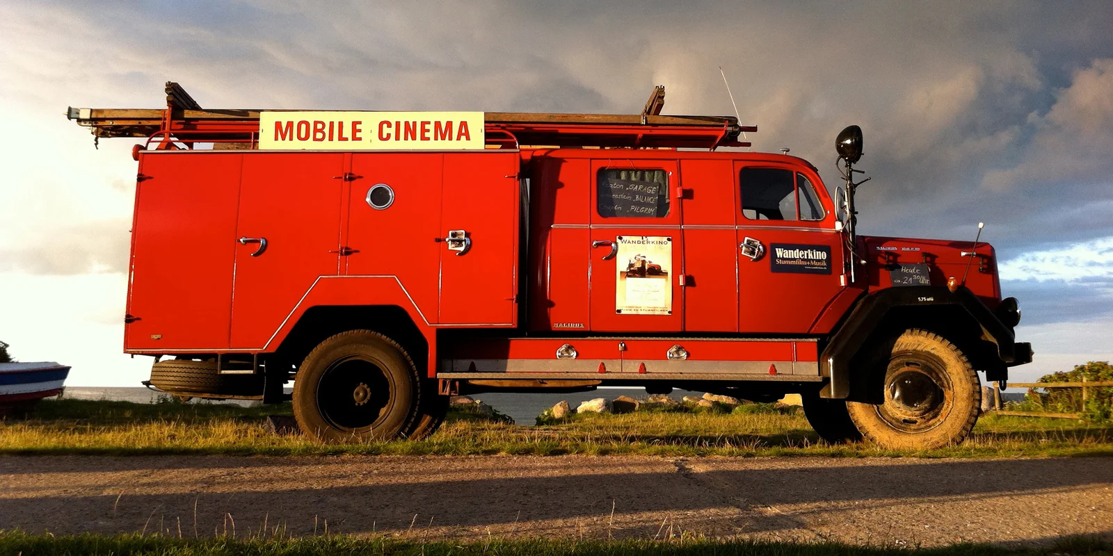 Ein rotes altes Feuerwehrauto mit der Aufschrift „Mobile Cinema“