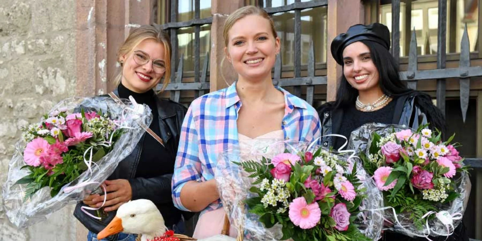 Drei Frauen mit Blumen und eine Gans im Korb