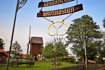 Das Schild des Europäischen Brotmuseums mit der historischen Mühle im Hintergrund