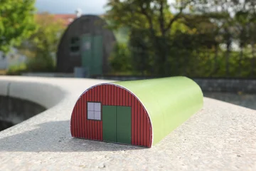 grüner Bastelbogen der Nissenhütte vor der originalen Hütte