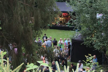 Blick zwischen den Bäumen auf die Bühne beim 1. „Rock am Teich“