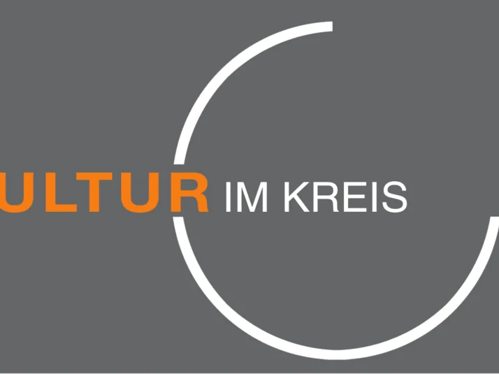Logo "Kultur im Kreis" - "Kultur" in orangener Schrift, "im Kreis" in weißer und in einem zu drei vierteln geschlossenen weißen Kreis stehend.