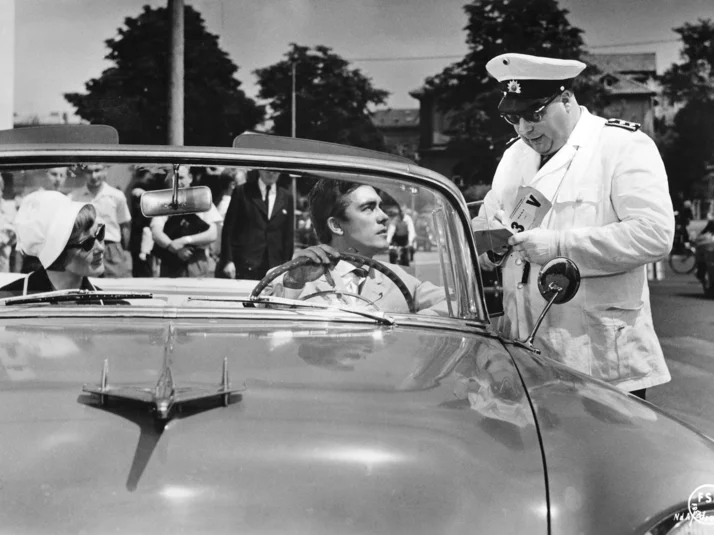 Foto aus dem Film Natürlich die Autofahrer. Heinz Ehrhard als Polizist kontrolliert ein Cabriole mit Erik Schumann mit weiblicher Begleitung am Weender Tor (Blickrichtung Nikolausberger Weg). 